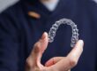 man holding Invisalign aligner